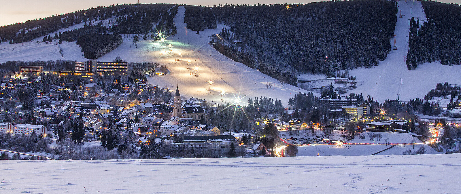 Kurort Oberwiesenthal im Erzgebirge mit beleuchtetem Skihang